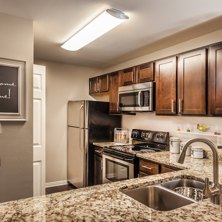 Spacious kitchen with granite counter tops, dark wood cabinetry, and stainless steel appliances